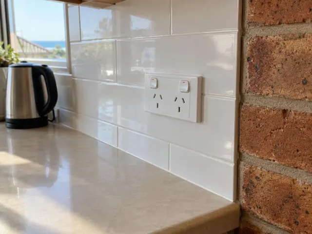 Double power point on a white tiled kitchen splashback beside a brick wall in Blacksmiths