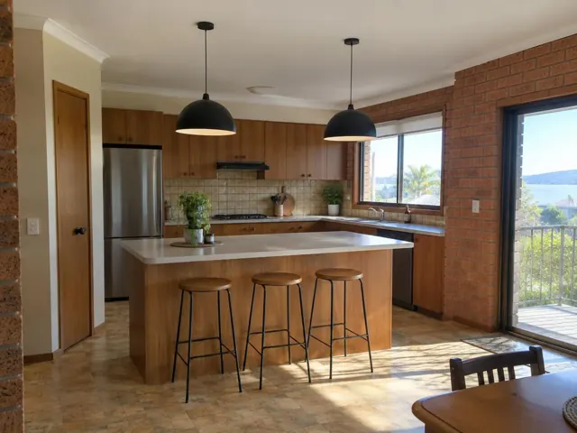 Kitchen with two black pendant lights over an island, wood cabinetry and brick walls in Swansea Heads